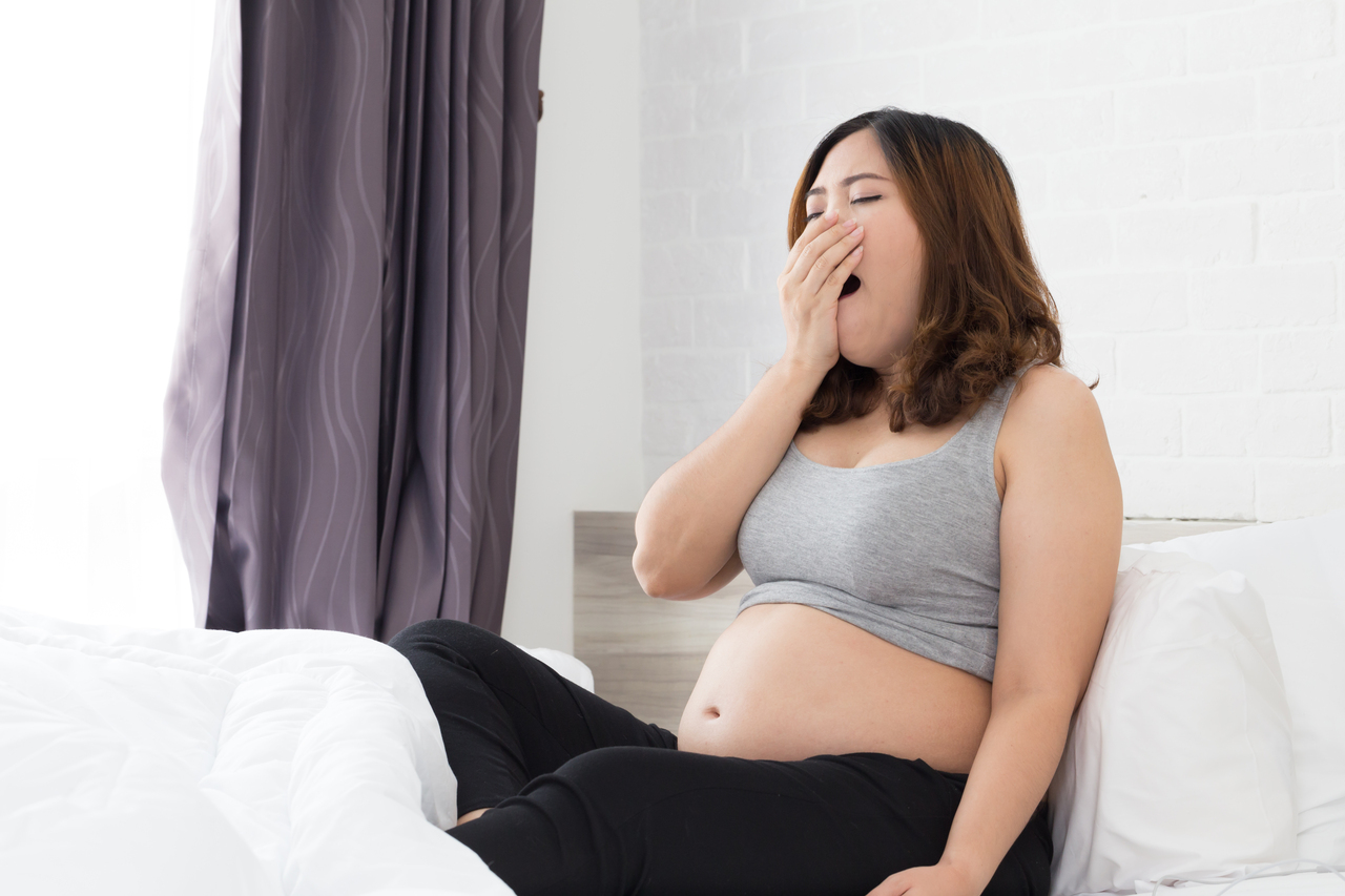 A pregnant woman covering her nose