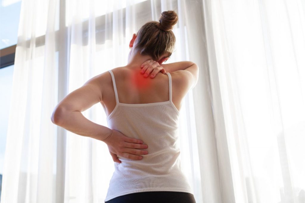 Woman experiencing back pain after waking up