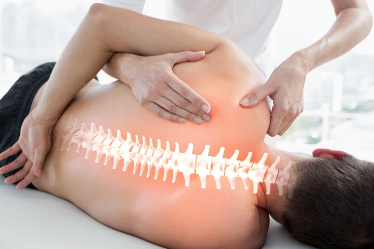 Chiropractor performing a gentle spinal adjustment on a patient