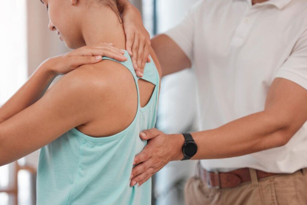 Chiropractor assessing a patient’s upper back and posture during treatment