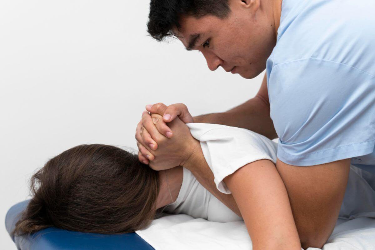 Chiropractor performing an upper back adjustment on a patient lying face down
