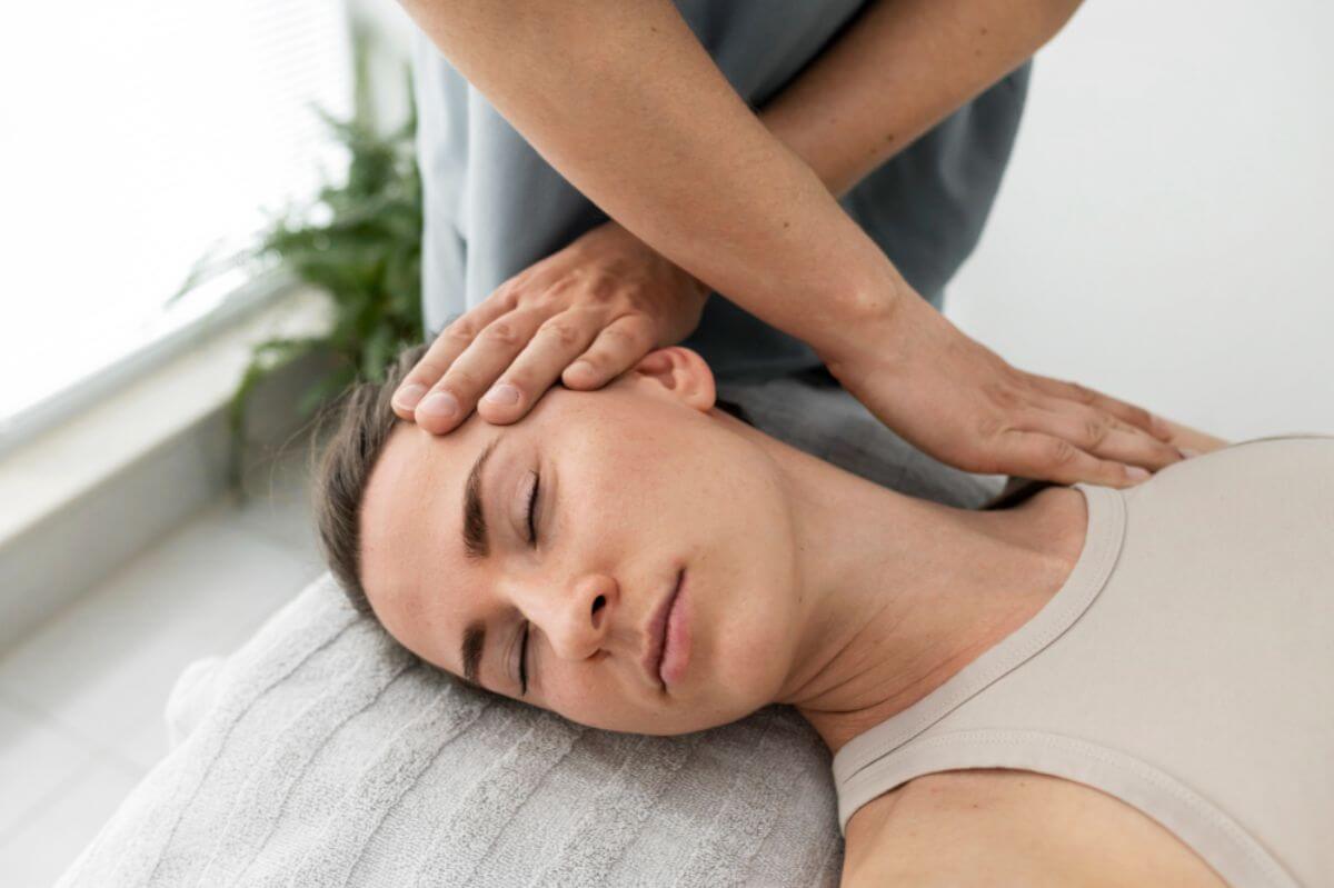 Chiropractor applying gentle neck and shoulder therapy to a patient