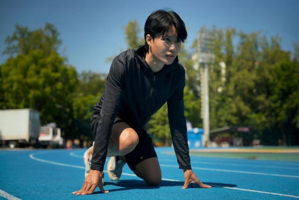 Athlete preparing to sprint on an outdoor track during training