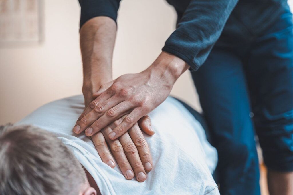 Chiropractor performing a back adjustment to help address chronic back pain without medication
